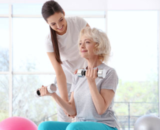 health professional assist a senior woman doing exercise