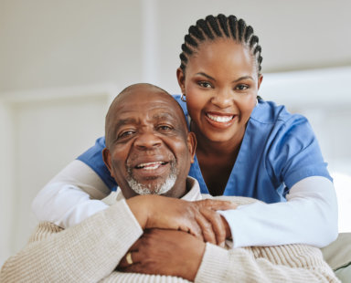 senior man and a caregiver smiling