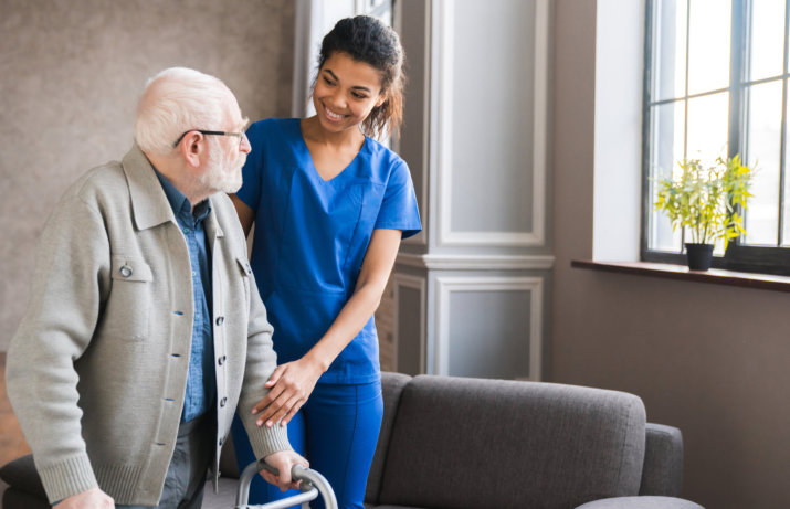 caregiver and a senior man with a walker