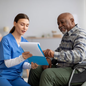 elderly man pointing a form while a nurse handles it