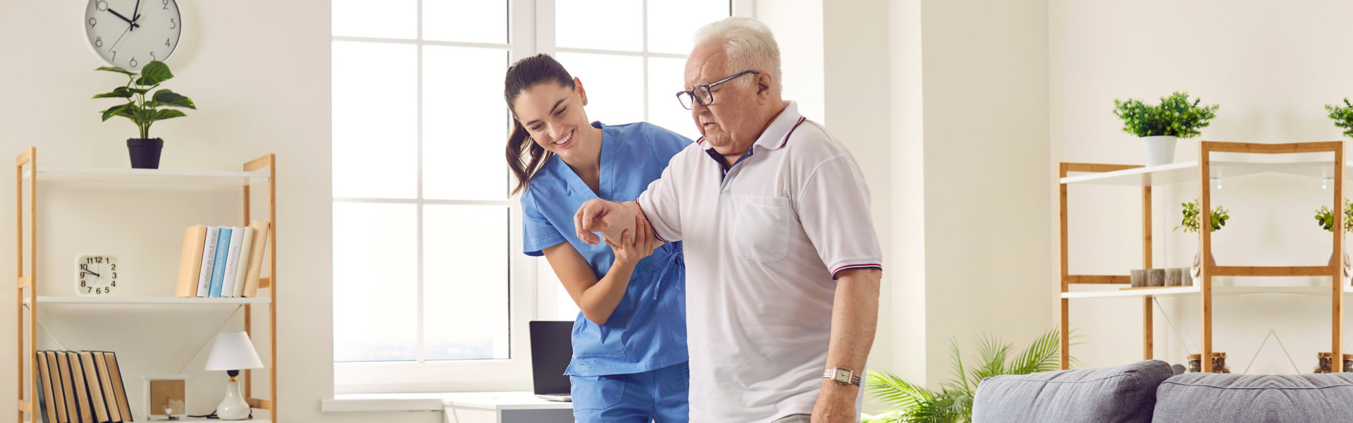 caregiver helps a senior man to walk